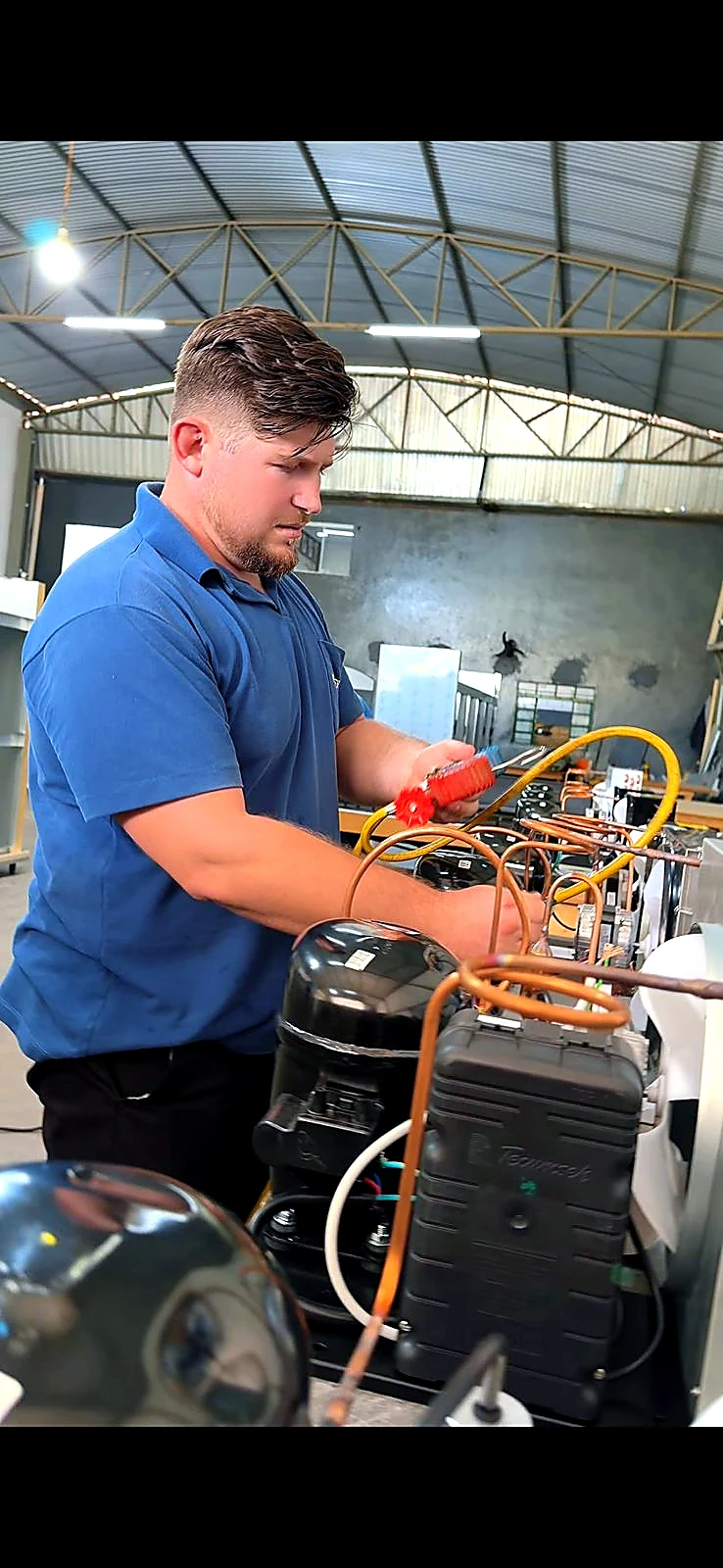 Equipe POWERTEC trabalhando em bancada técnica durante montagem de equipamentos refrigerados