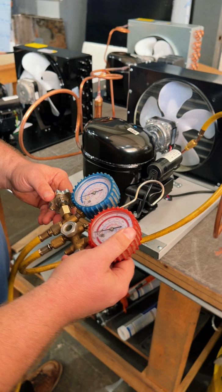 Técnico POWERTEC regulando válvulas e manômetros em sistema de refrigeração comercial